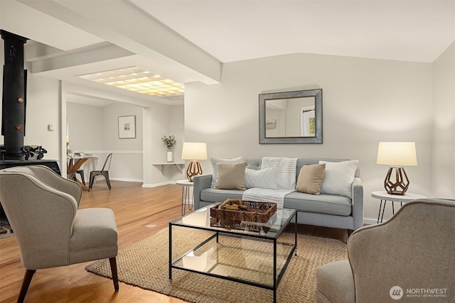 living area featuring lofted ceiling, baseboards, and wood finished floors