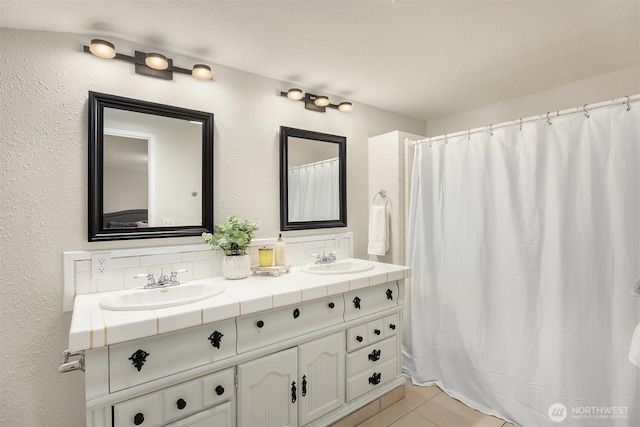 bathroom featuring double vanity, curtained shower, tile patterned flooring, and a sink