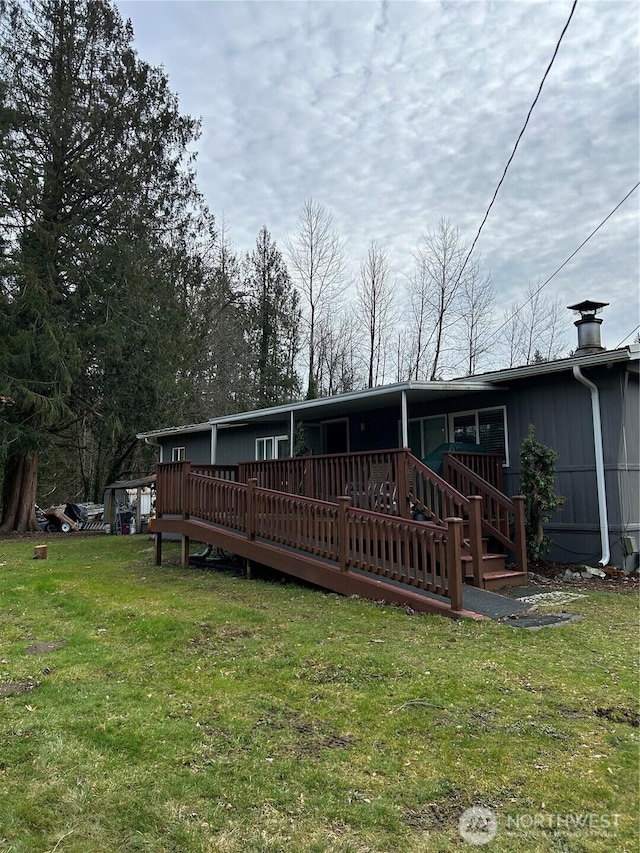 rear view of property with a wooden deck and a yard