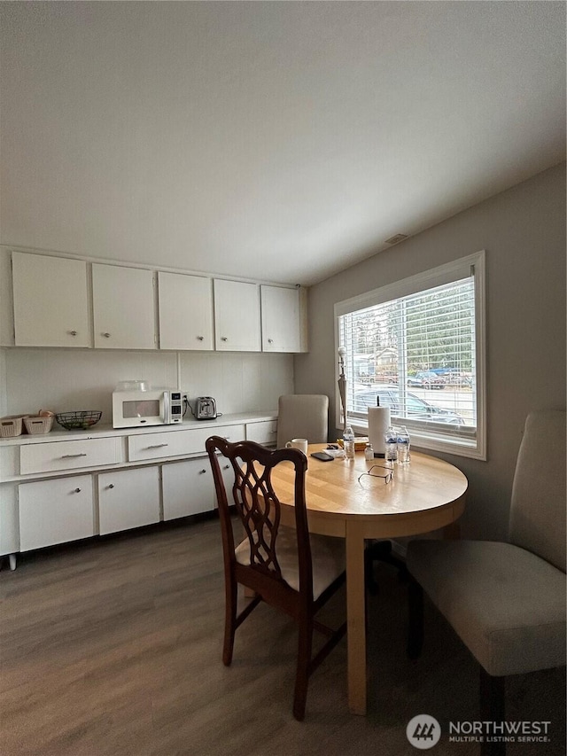 dining area with dark wood-style flooring