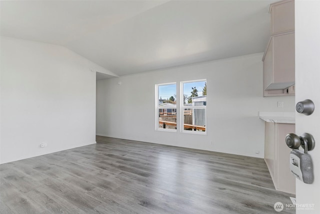 unfurnished living room featuring vaulted ceiling and wood finished floors