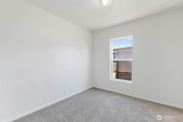 carpeted spare room featuring baseboards