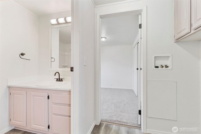 bathroom with vanity, baseboards, and wood finished floors