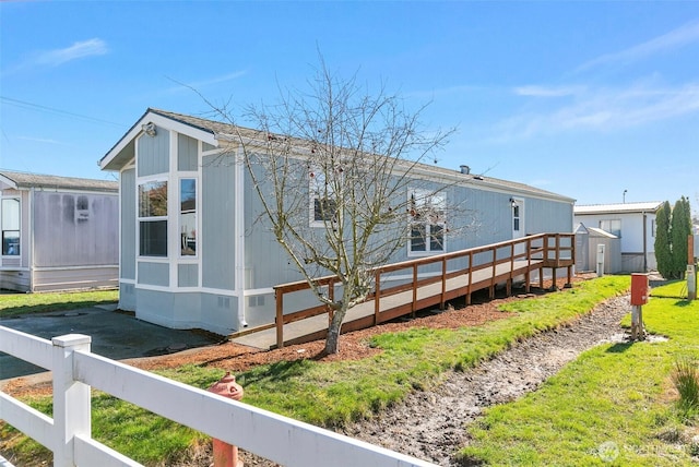 view of side of property with an outbuilding, a shed, and fence