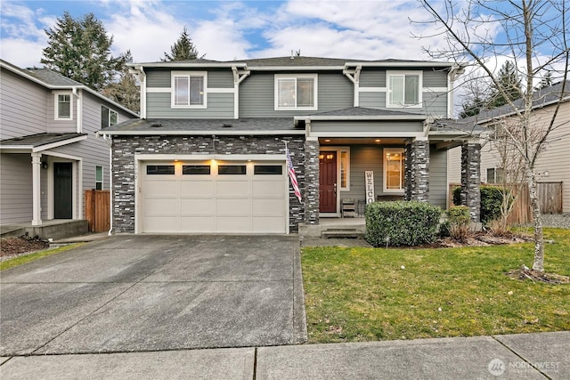 view of front facade with a garage, concrete driveway, stone siding, fence, and a front yard