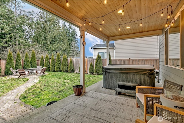 view of patio / terrace featuring a hot tub, a fire pit, and a fenced backyard