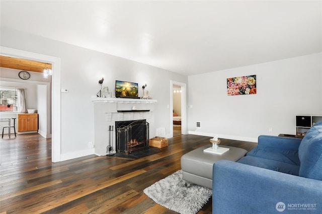 living room with a fireplace, wood-type flooring, and baseboards