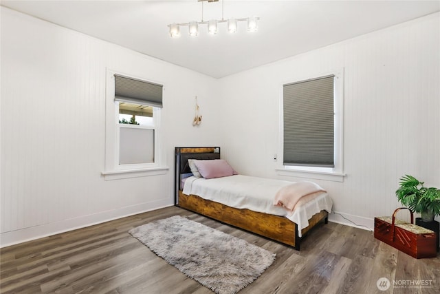 bedroom with baseboards and wood finished floors