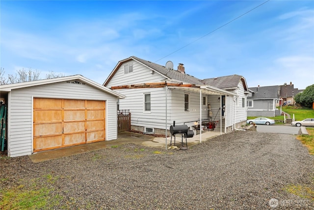 view of front facade with an outdoor structure, driveway, and a detached garage