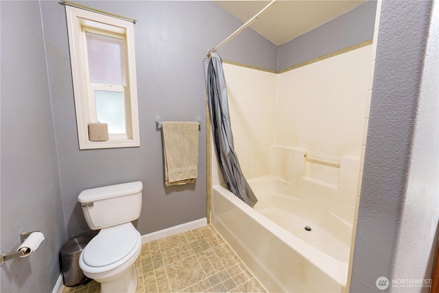 bathroom featuring shower / bath combo, baseboards, and toilet