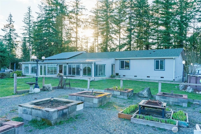 back of property featuring a lawn, crawl space, and a garden