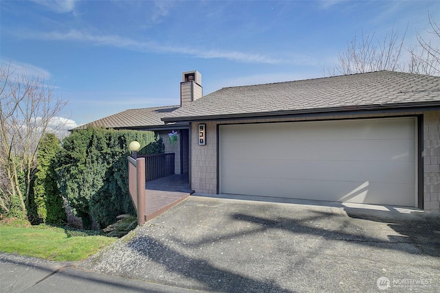 single story home featuring a garage, a shingled roof, and a chimney