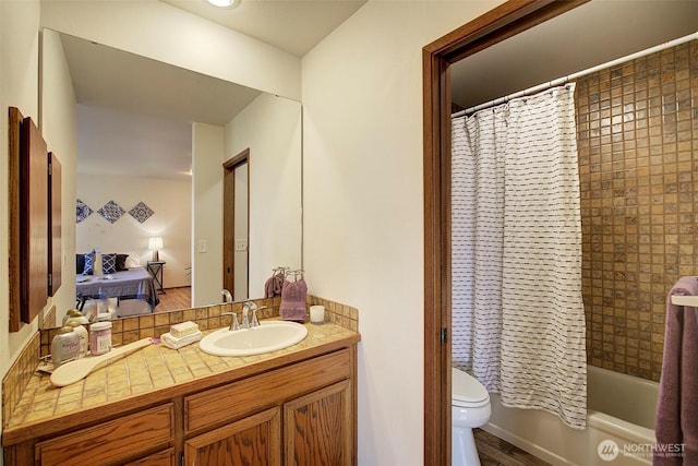 bathroom with toilet, shower / bath combination with curtain, and vanity