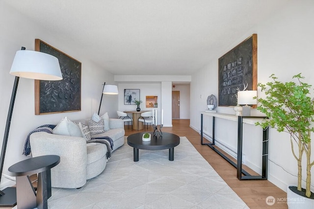 living area with baseboards and wood finished floors