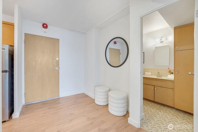 interior space featuring wood finished floors, vanity, and baseboards