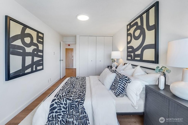 bedroom featuring a closet, wood finished floors, and baseboards