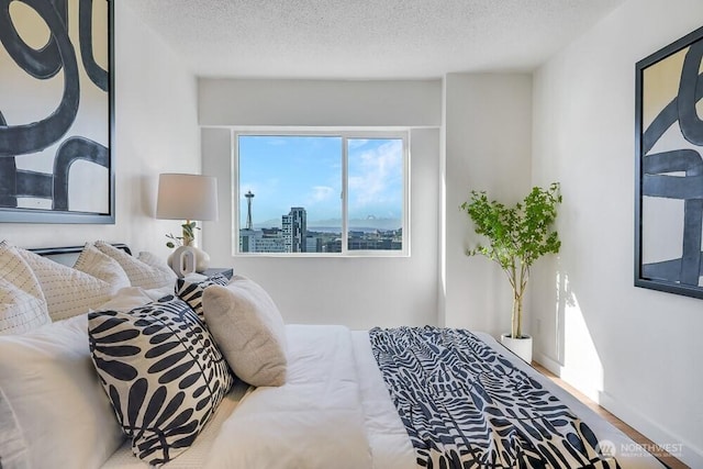 bedroom with a textured ceiling and wood finished floors