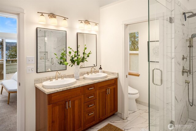 bathroom featuring marble finish floor, double vanity, a stall shower, and a sink