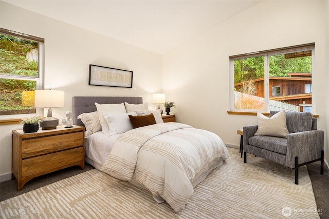 carpeted bedroom with lofted ceiling and baseboards