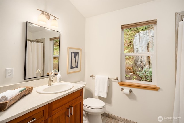 full bath featuring plenty of natural light, vanity, and toilet