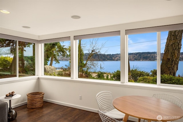 sunroom featuring a water view