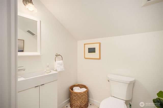 half bathroom featuring vaulted ceiling, toilet, vanity, and visible vents