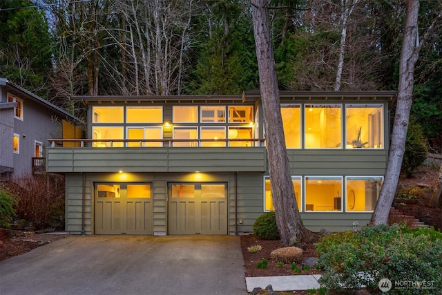 view of front of property with driveway, a balcony, and a garage