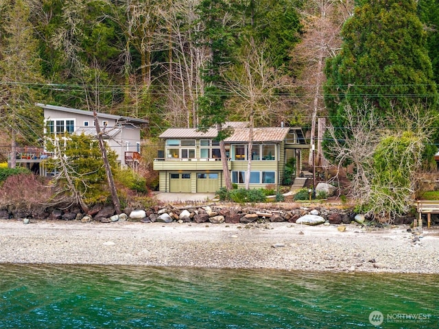 rear view of property with a water view