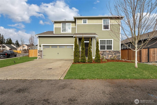 view of front of home with stone siding, concrete driveway, a front yard, and fence