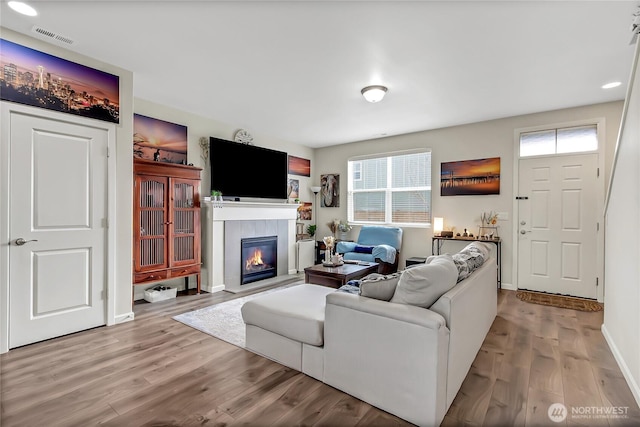 living room featuring a healthy amount of sunlight, visible vents, and wood finished floors