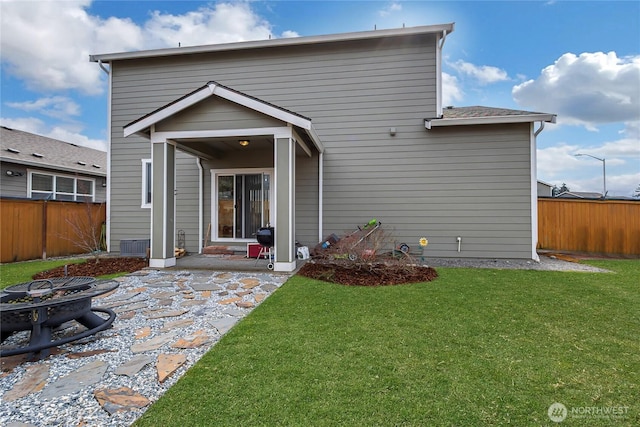 rear view of property with an outdoor fire pit, a patio area, a lawn, and fence