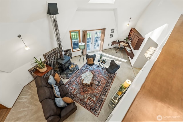 living room with a wood stove, french doors, carpet floors, and a high ceiling