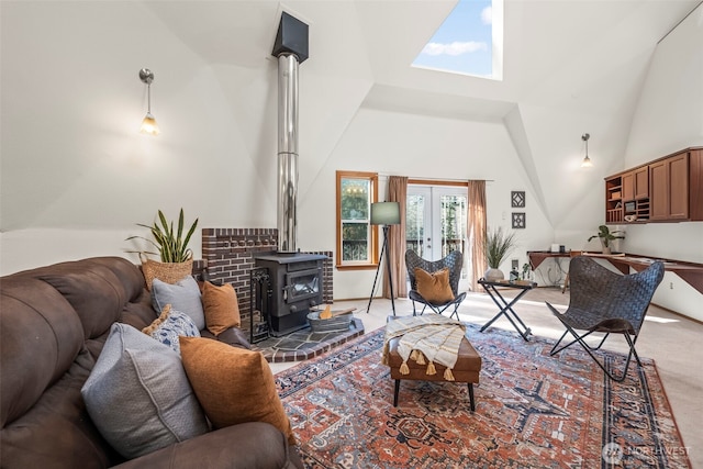 living area with a wood stove, high vaulted ceiling, french doors, and light colored carpet