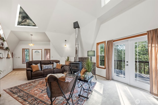 living area featuring lofted ceiling, light carpet, baseboards, french doors, and a wood stove