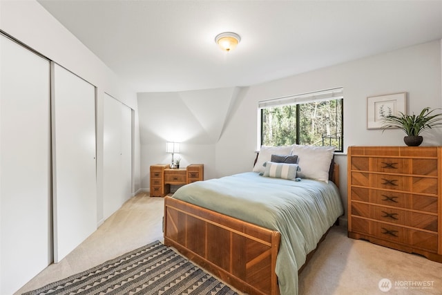 bedroom featuring two closets and light colored carpet