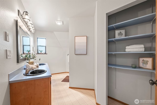 bathroom with a sink, baseboards, and tile patterned floors