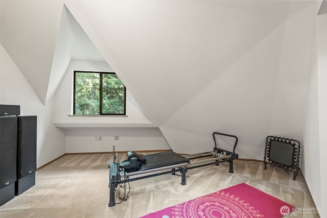 workout room featuring vaulted ceiling, carpet, and baseboards