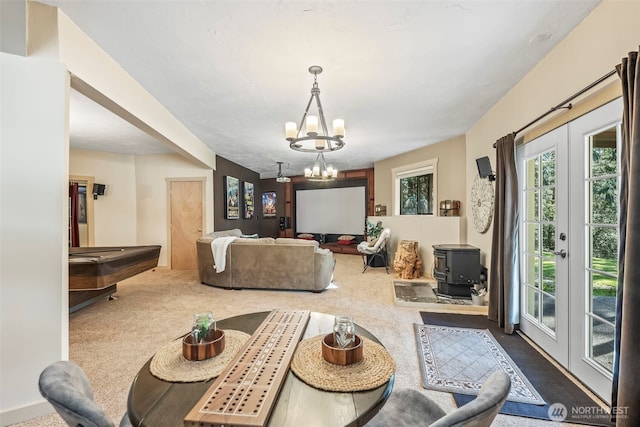 carpeted dining room with a chandelier, french doors, billiards, and a wood stove