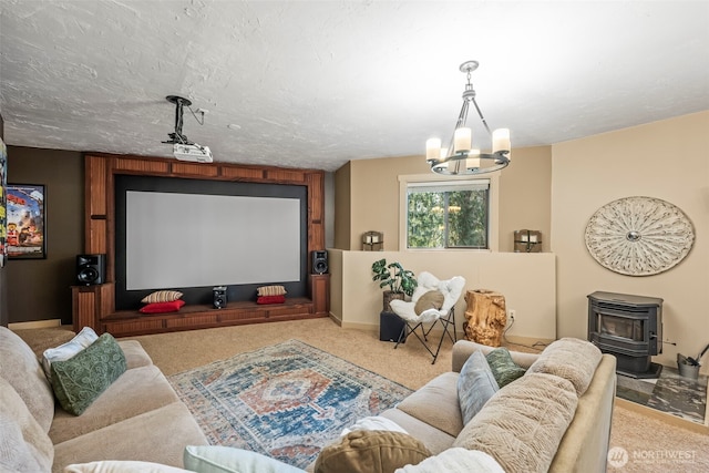 cinema room featuring a textured ceiling, carpet flooring, a wood stove, and an inviting chandelier