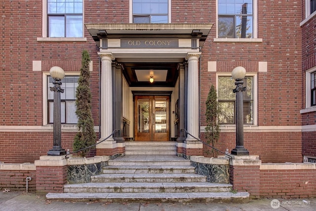 property entrance featuring french doors and brick siding