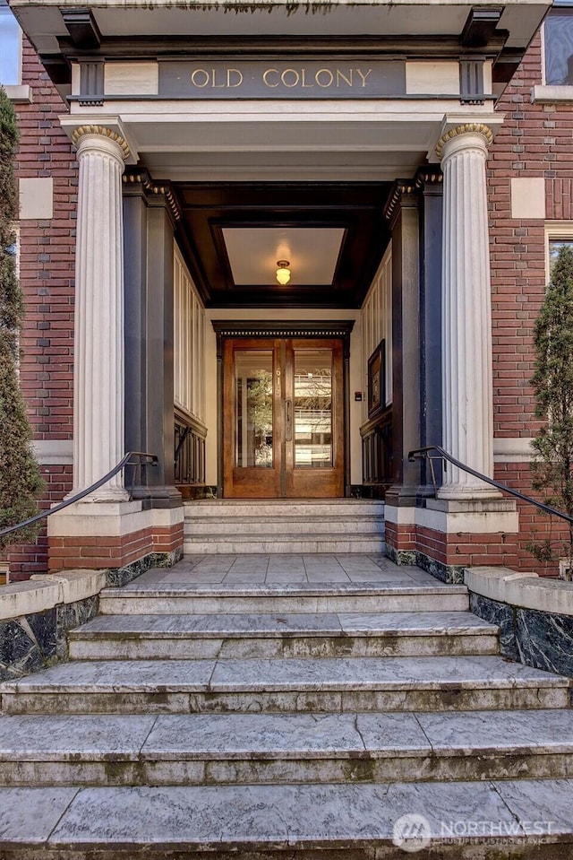 doorway to property with brick siding