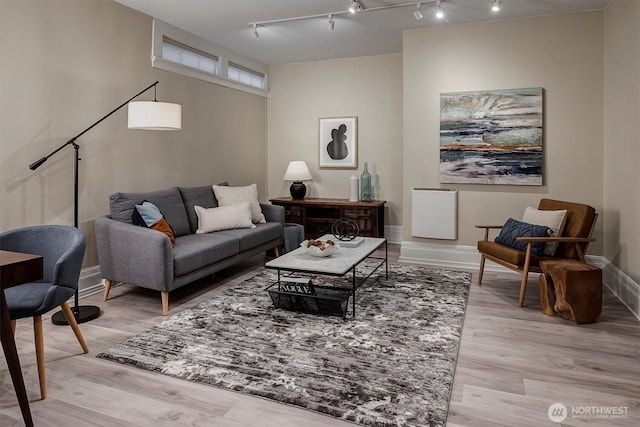 living area featuring light wood-style flooring and baseboards