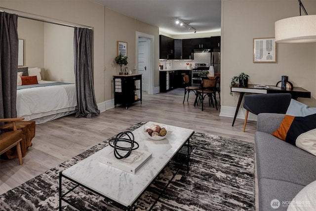 living area with light wood-style floors and baseboards