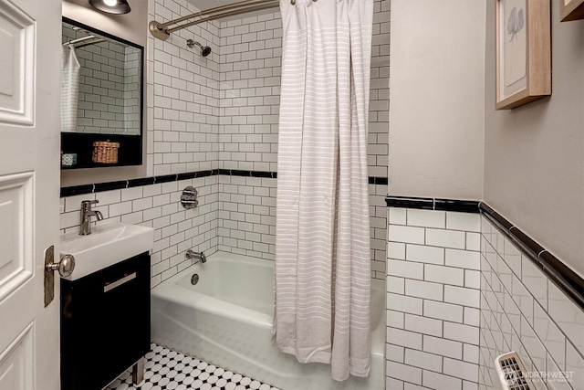 full bath with shower / tub combo, vanity, and tile walls