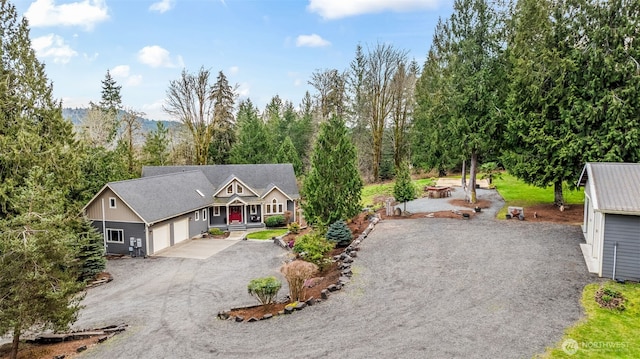 view of front facade with gravel driveway and a fire pit