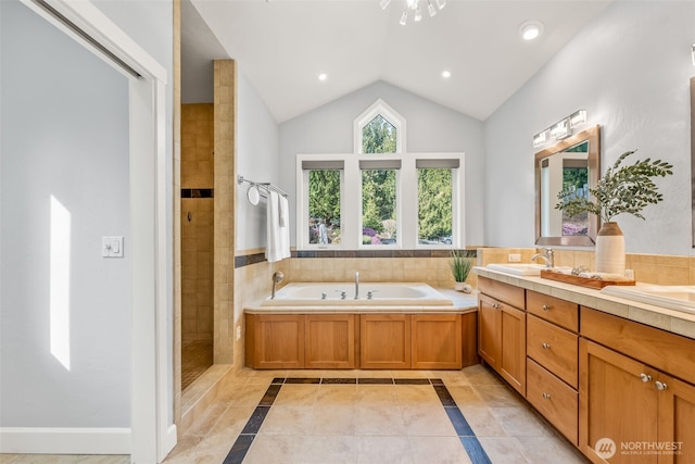 full bath featuring lofted ceiling, double vanity, recessed lighting, a bath, and a sink