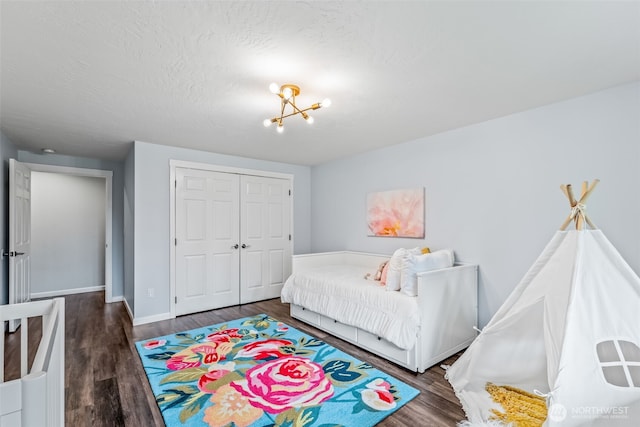 bedroom featuring a closet, baseboards, a textured ceiling, and wood finished floors