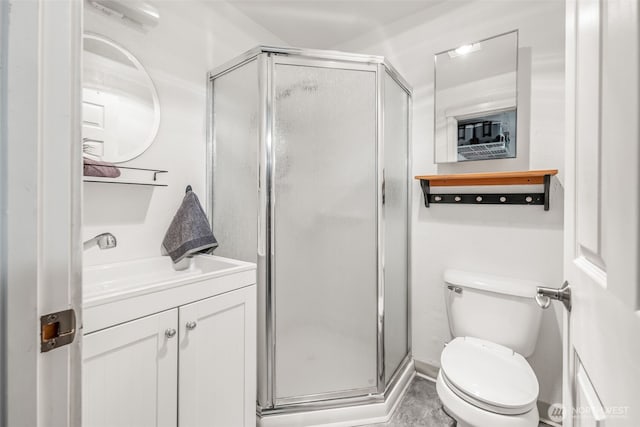 bathroom featuring vanity, toilet, and a stall shower