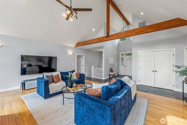 living area featuring beamed ceiling, baseboards, high vaulted ceiling, and hardwood / wood-style flooring