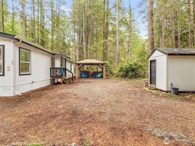 view of yard featuring a storage unit, a carport, and an outdoor structure